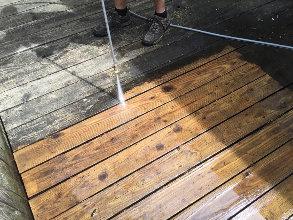 Cleaning a wooden patio with a pressure washer